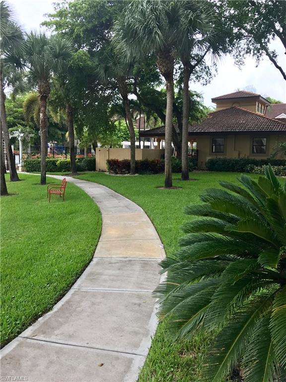 2214 Arbour Walk Circle, Unit 2012 Naples, FL 34109 - Photo 15 of 17 a front view of a house with a garden