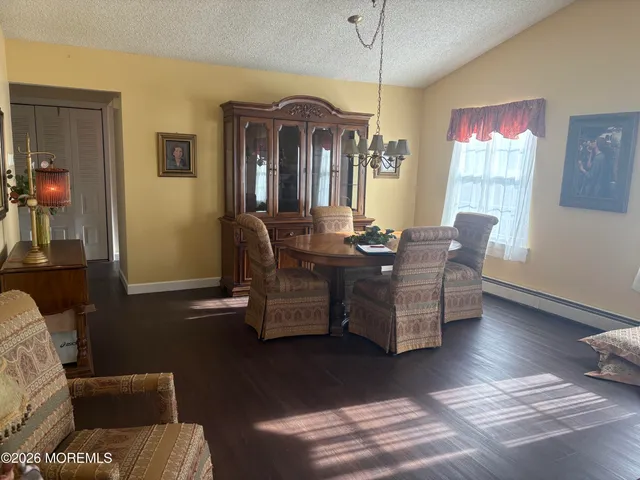 a dining room with furniture a chandelier and wooden floor