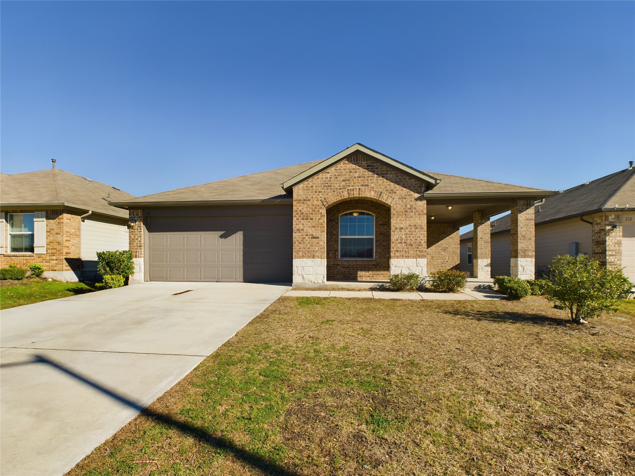 Ranch-style house with a front yard and a garage