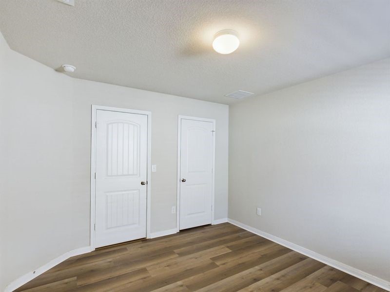 114 Cranbrook Lane Hutto, TX 78634 - Photo 12 of 38 Unfurnished bedroom with dark wood-type flooring and a textured ceiling