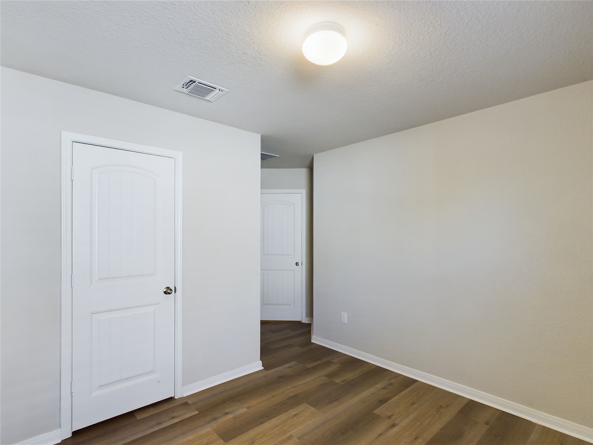 114 Cranbrook Lane Hutto, TX 78634 - Photo 15 of 38 Unfurnished bedroom featuring a textured ceiling and dark hardwood / wood-style flooring