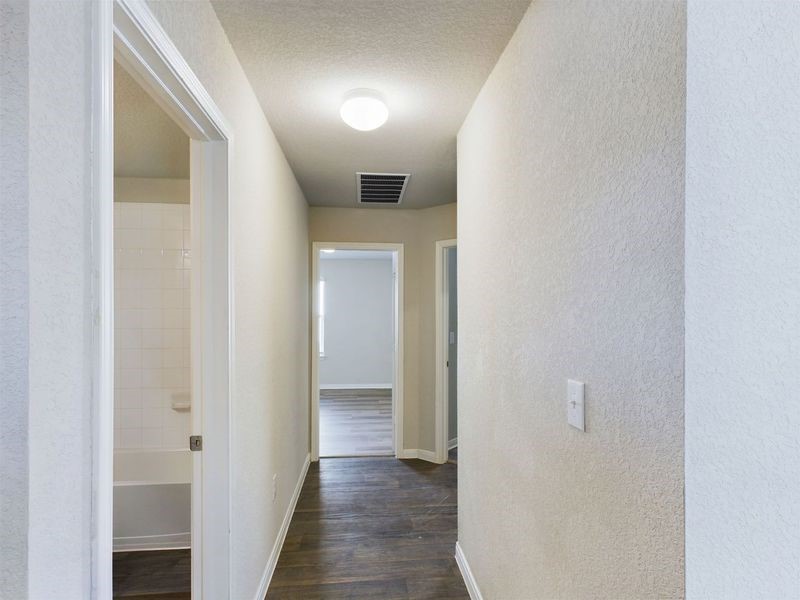 114 Cranbrook Lane Hutto, TX 78634 - Photo 23 of 38 Corridor featuring dark wood-type flooring and a textured ceiling