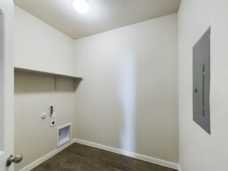 114 Cranbrook Lane Hutto, TX 78634 - Photo 26 of 38 Laundry area featuring dark hardwood / wood-style floors, electric dryer hookup, a textured ceiling, electric panel, and gas dryer hookup