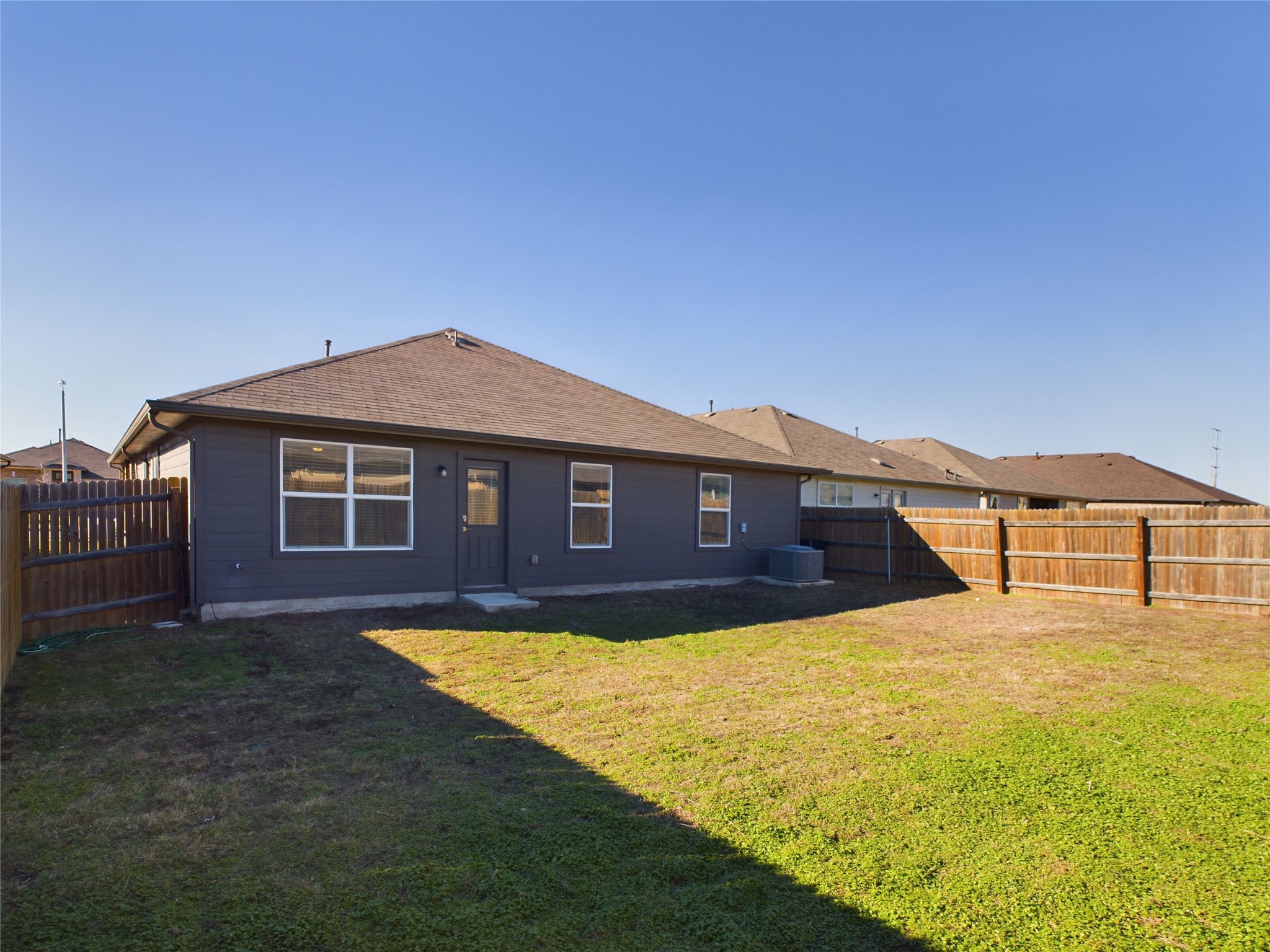 114 Cranbrook Lane Hutto, TX 78634 - Photo 36 of 38 Rear view of house featuring cooling unit and a yard