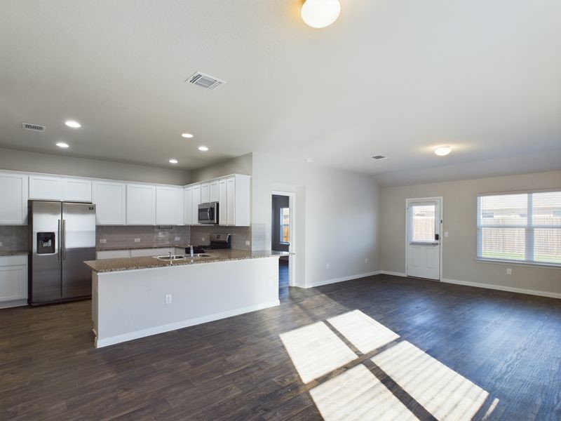 114 Cranbrook Lane Hutto, TX 78634 - Photo 8 of 38 Kitchen with tasteful backsplash, stone counters, white cabinetry, stainless steel appliances, and dark hardwood / wood-style flooring