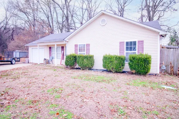 a view of a house with a yard and pathway