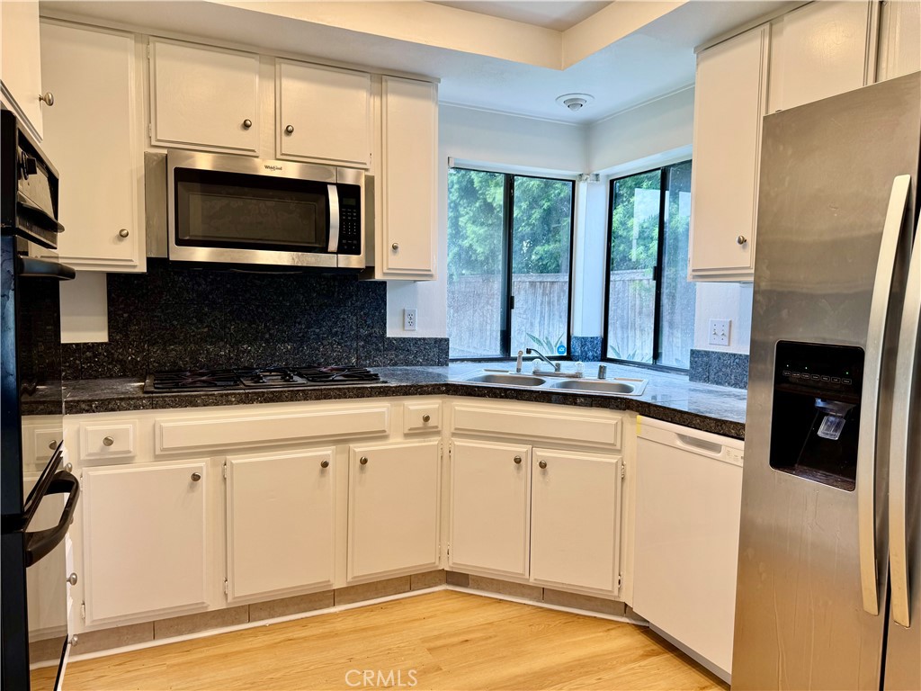 3 Atlanta Irvine, CA 92620 - Photo 3 of 14 a kitchen with stainless steel appliances granite countertop a stove a microwave and a sink