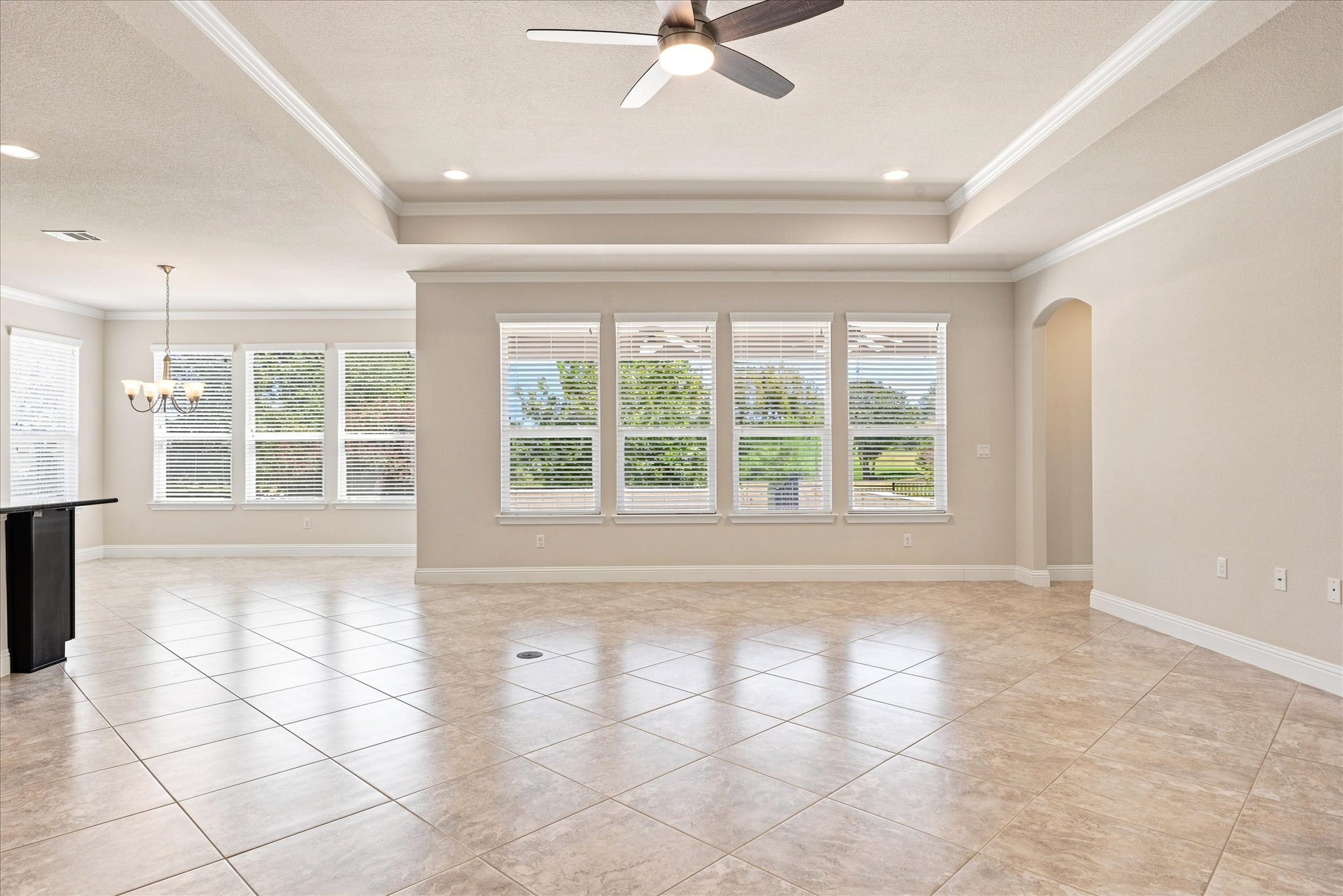 Gleaming tile floors and a tray ceiling define this open, airy living space.