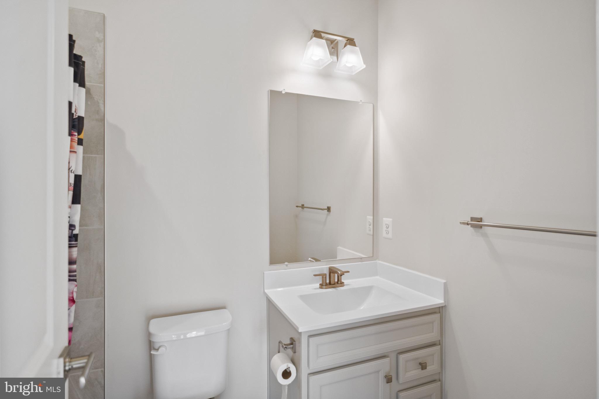 734 Watts Street Baltimore, MD 21217 - Photo 21 of 25 a bathroom with a sink toilet and vanity