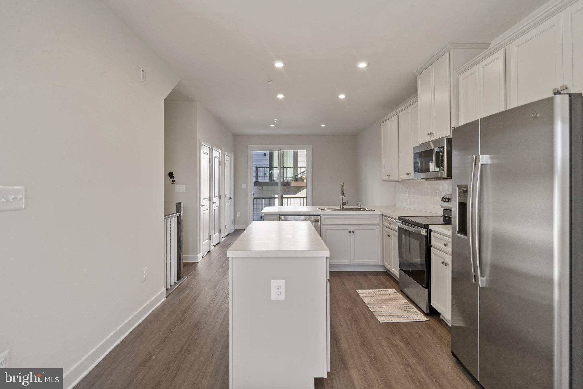 734 Watts Street Baltimore, MD 21217 - Photo 8 of 25 a kitchen with white cabinets and stainless steel appliances