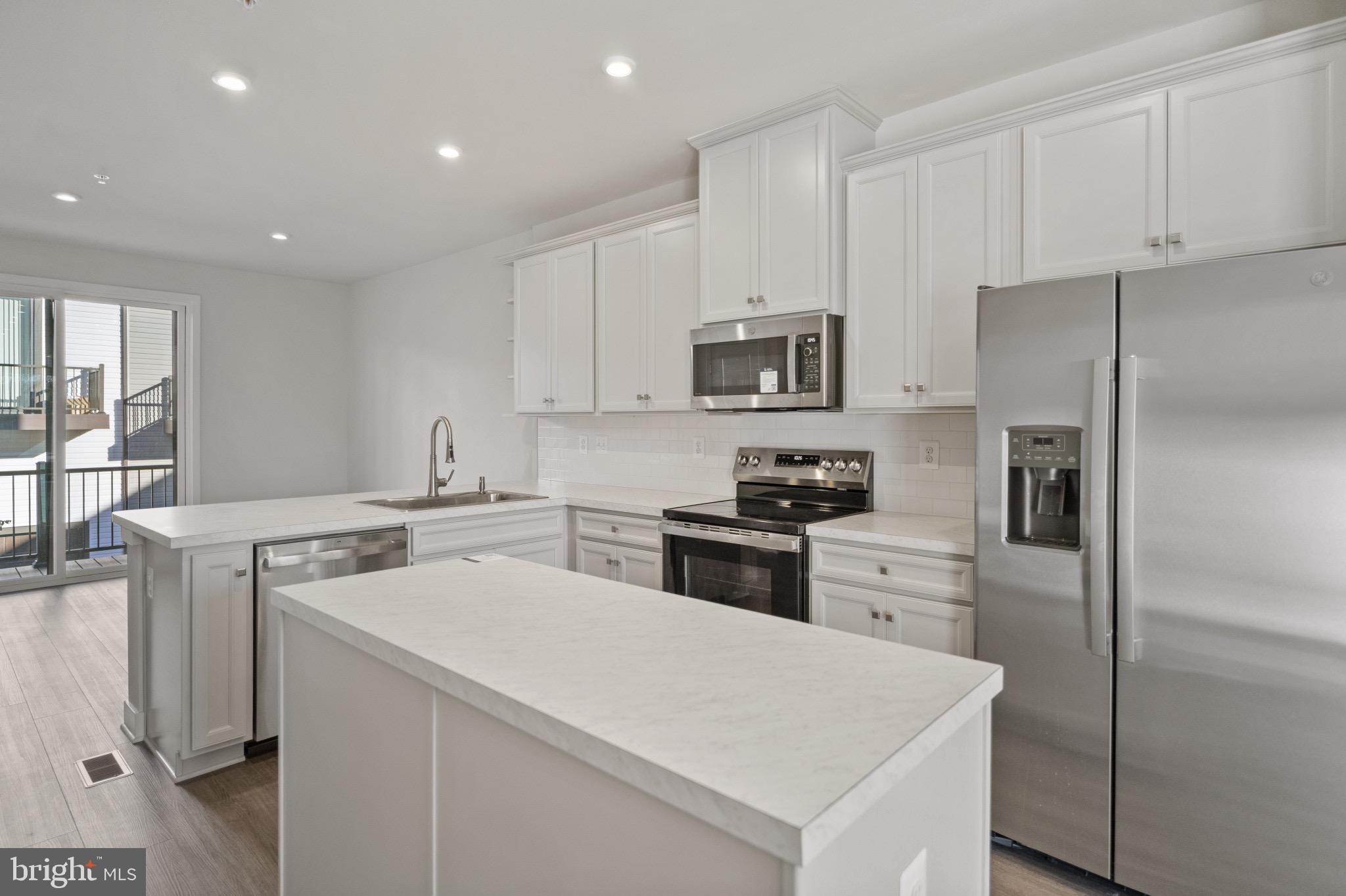 734 Watts Street Baltimore, MD 21217 - Photo 9 of 25 a kitchen with a sink a stove a refrigerator and white cabinets