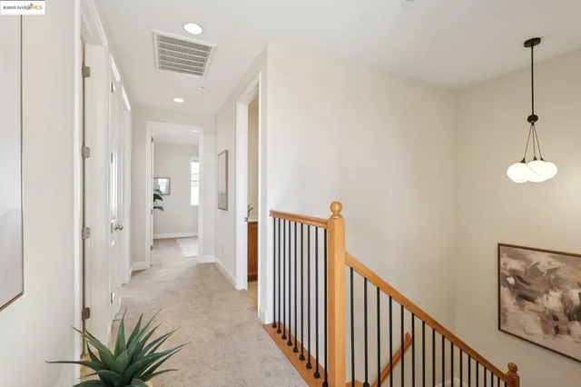 a view of a hallway with wooden floor and a living room