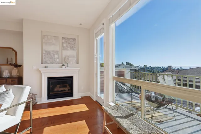 a living room with furniture a fireplace and a floor to ceiling window