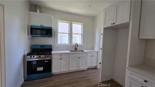 a kitchen with stainless steel appliances a stove microwave and sink