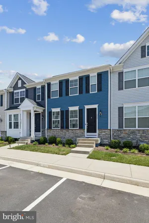 a front view of residential houses with yard and traffic signal