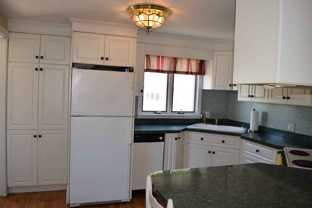32 Rita Street Springfield, MA 01118 - Photo 7 of 29 a kitchen with granite countertop a refrigerator a sink a stove and a window