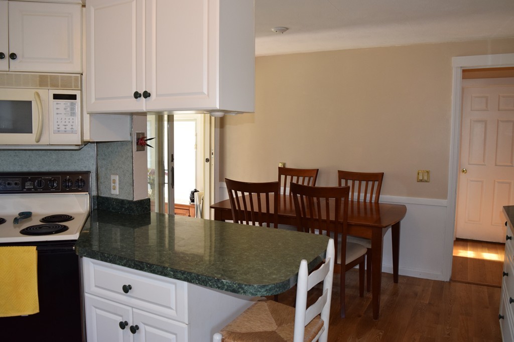 32 Rita Street Springfield, MA 01118 - Photo 9 of 29 a kitchen with granite countertop a stove a sink a refrigerator and white cabinets
