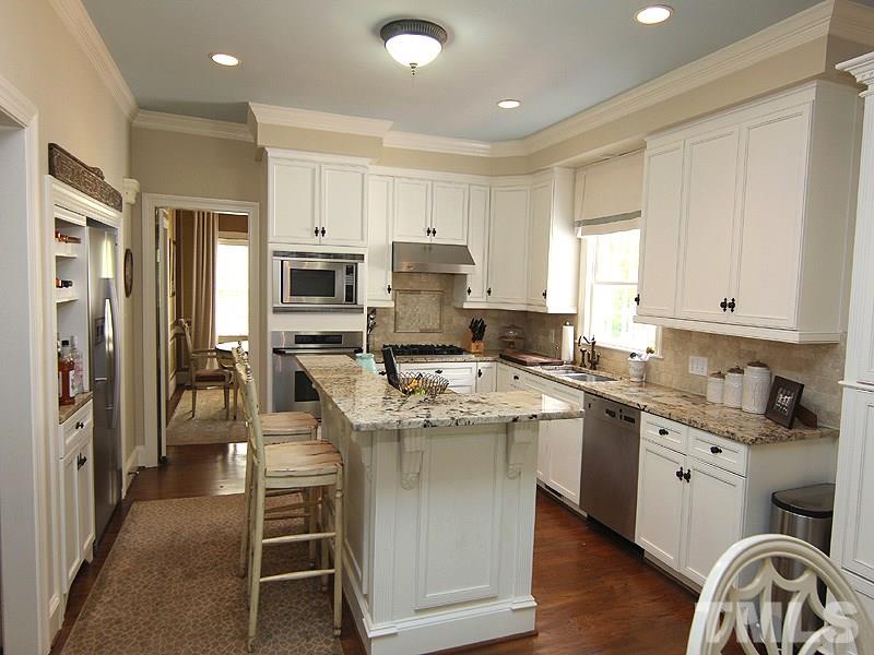2305 Tyson Street Raleigh, NC 27612 - Photo 8 of 25 a kitchen with granite countertop a sink stove refrigerator and cabinets