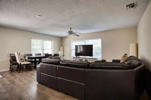 a living room with furniture kitchen view and a large window