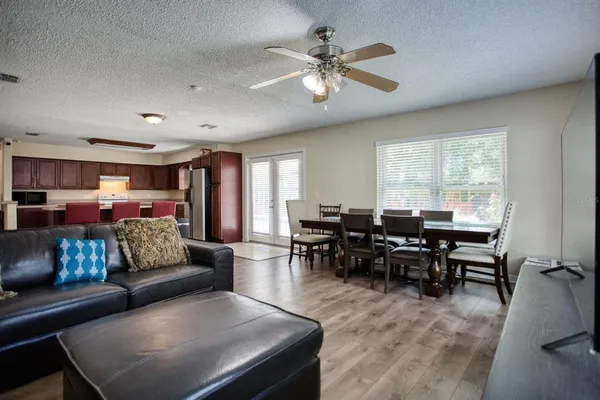 a bedroom with a bed couch and windows