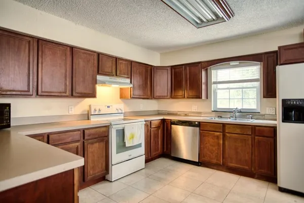 a kitchen with granite countertop a refrigerator and a stove