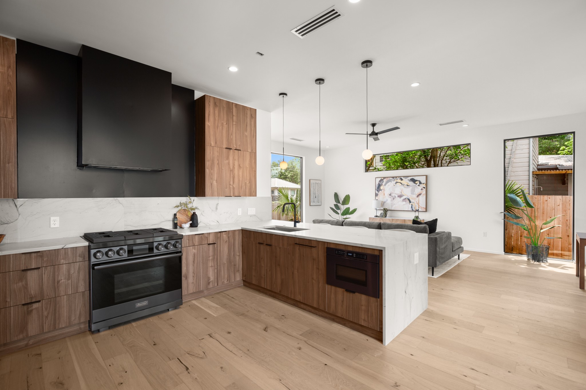 1805 Collier Street Austin, TX 78704 - Photo 39 of 39 Kitchen featuring open floor plan, modern cabinets, black appliances, light stone countertops, and decorative light fixtures