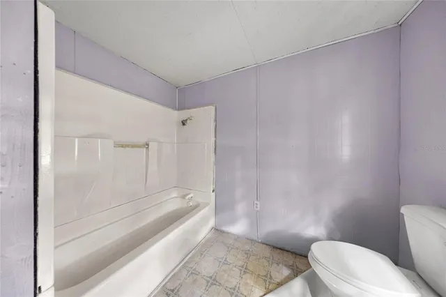 a bathroom with a granite countertop bathtub and toilet