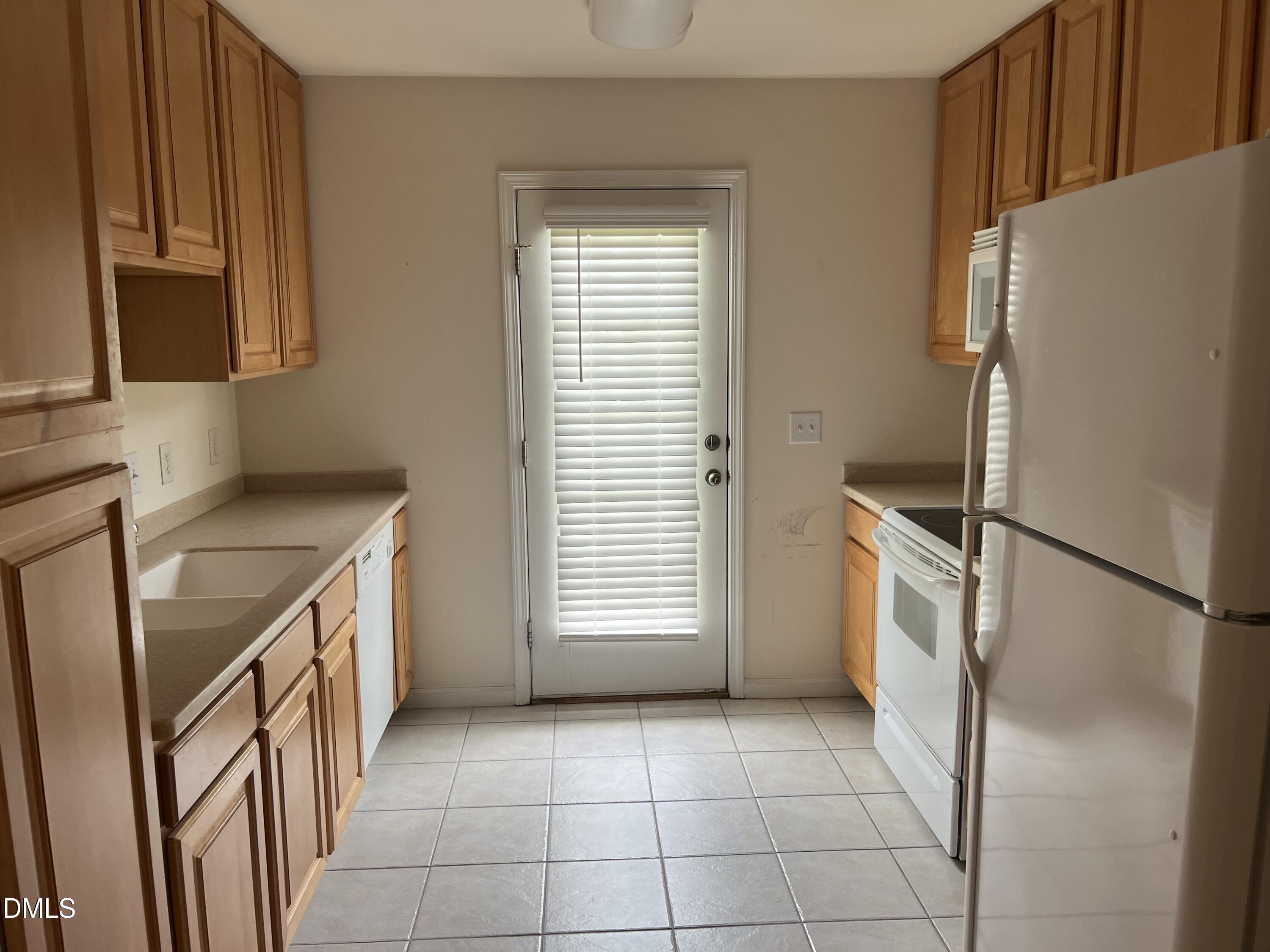 9827 Grettle Court Raleigh, NC 27617 - Photo 6 of 10 a kitchen with a refrigerator sink stove and cabinets