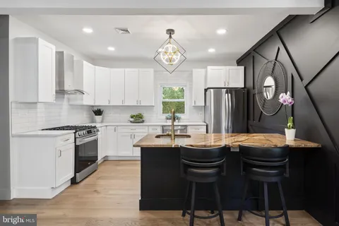 a kitchen with a stove a sink a refrigerator a center island and a cabinets