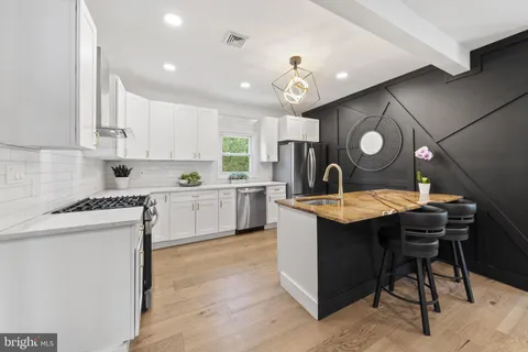 a kitchen with a sink white cabinets and stainless steel appliances