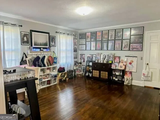 a living room with furniture and a flat screen tv with kitchen view