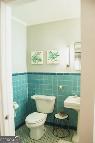 a bathroom with a toilet a sink and mirror