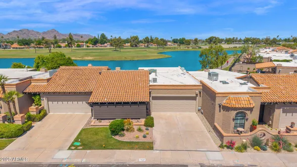 an aerial view of a house with a garden and lake view