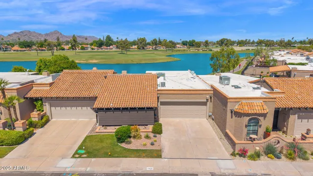 an aerial view of a house with a garden and lake view