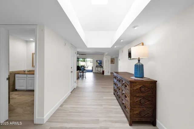 a view of a hallway to room with wooden floor