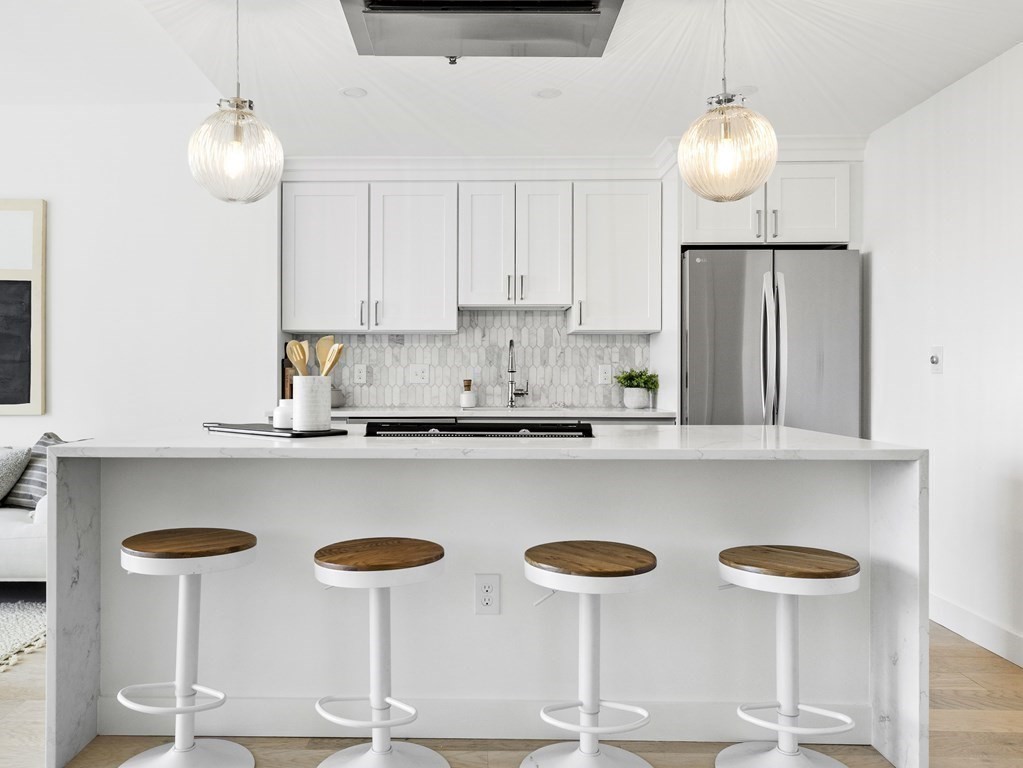 a kitchen with stainless steel appliances a table and chairs
