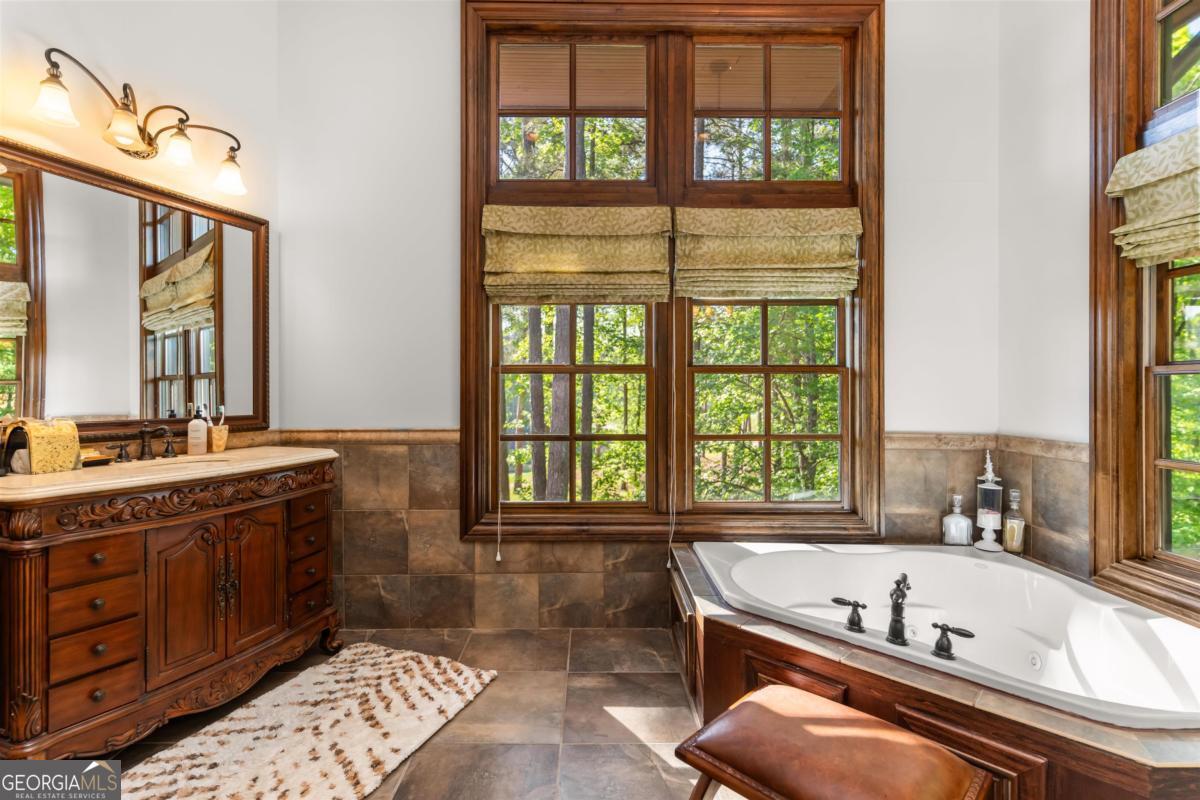 1090 Spring Creek Greensboro, GA 30642 - Photo 49 of 75 a bathroom with a tub a sink and a large window