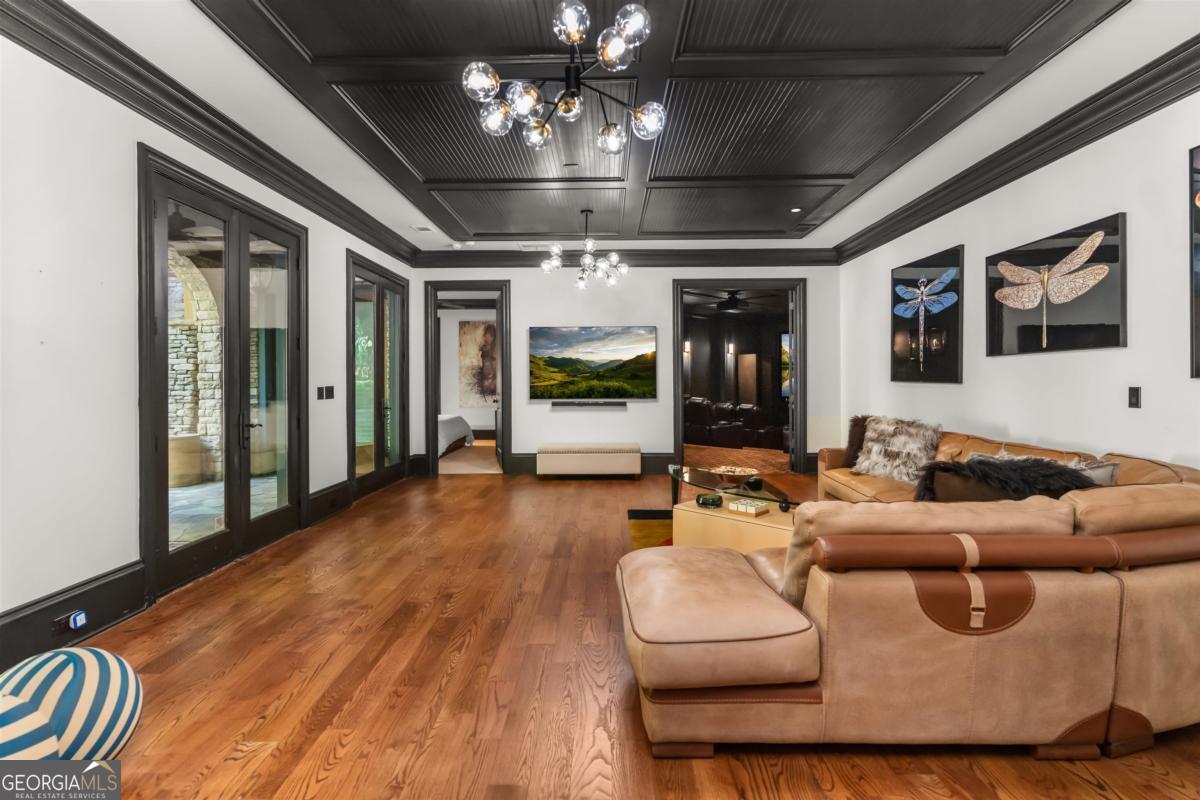 1090 Spring Creek Greensboro, GA 30642 - Photo 56 of 75 a living room with furniture a chandelier and a large window