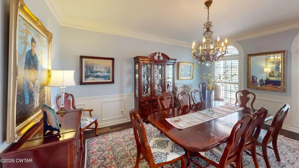 a view of a dining room with furniture a chandelier and wooden floor