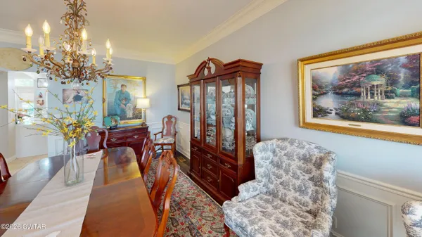 a living room with furniture a chandelier and a painting on the wall