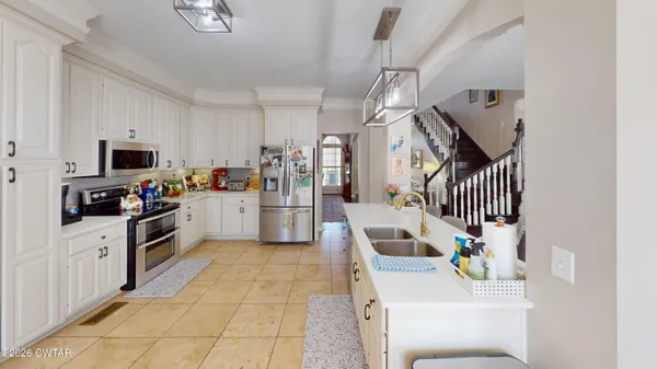 a kitchen with granite countertop a sink appliances and cabinets