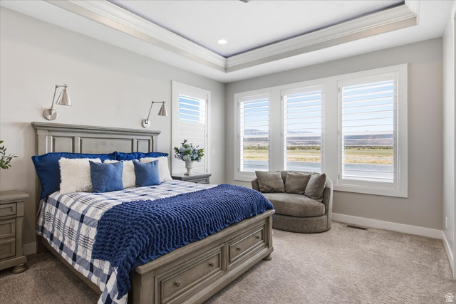 21 Pier Place Tooele, UT 84074 - Photo 32 of 112 Bedroom featuring a tray ceiling with recessed lighting, three large windows with plantation shutters, wall-mounted sconces, and neutral-toned carpeting