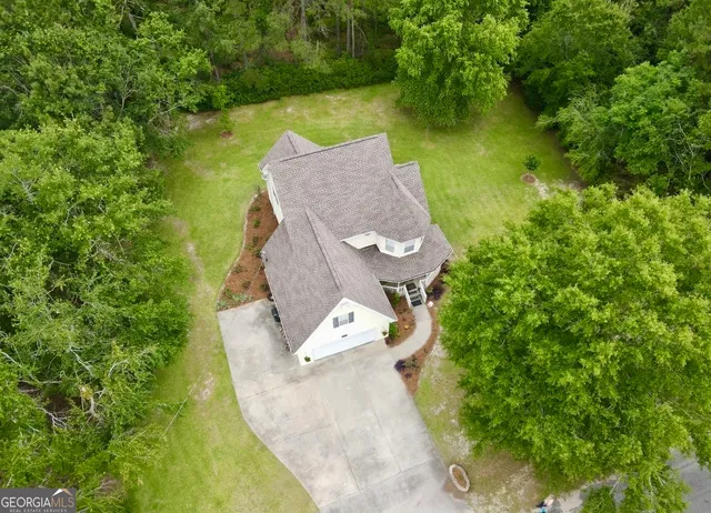 an aerial view of a house with swimming pool and garden