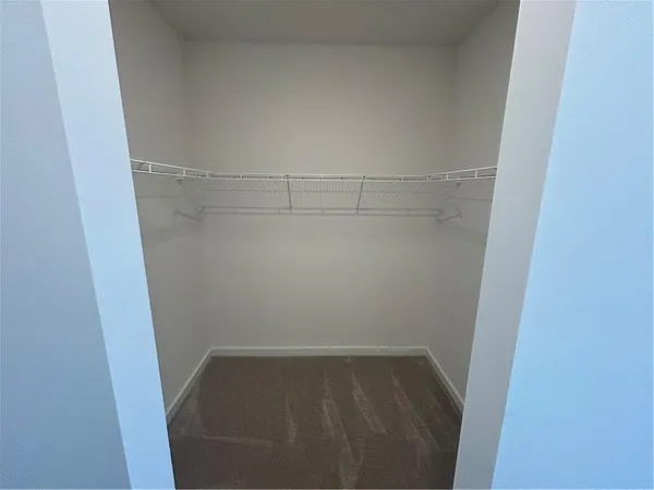 a white toilet sitting next to a wooden floor