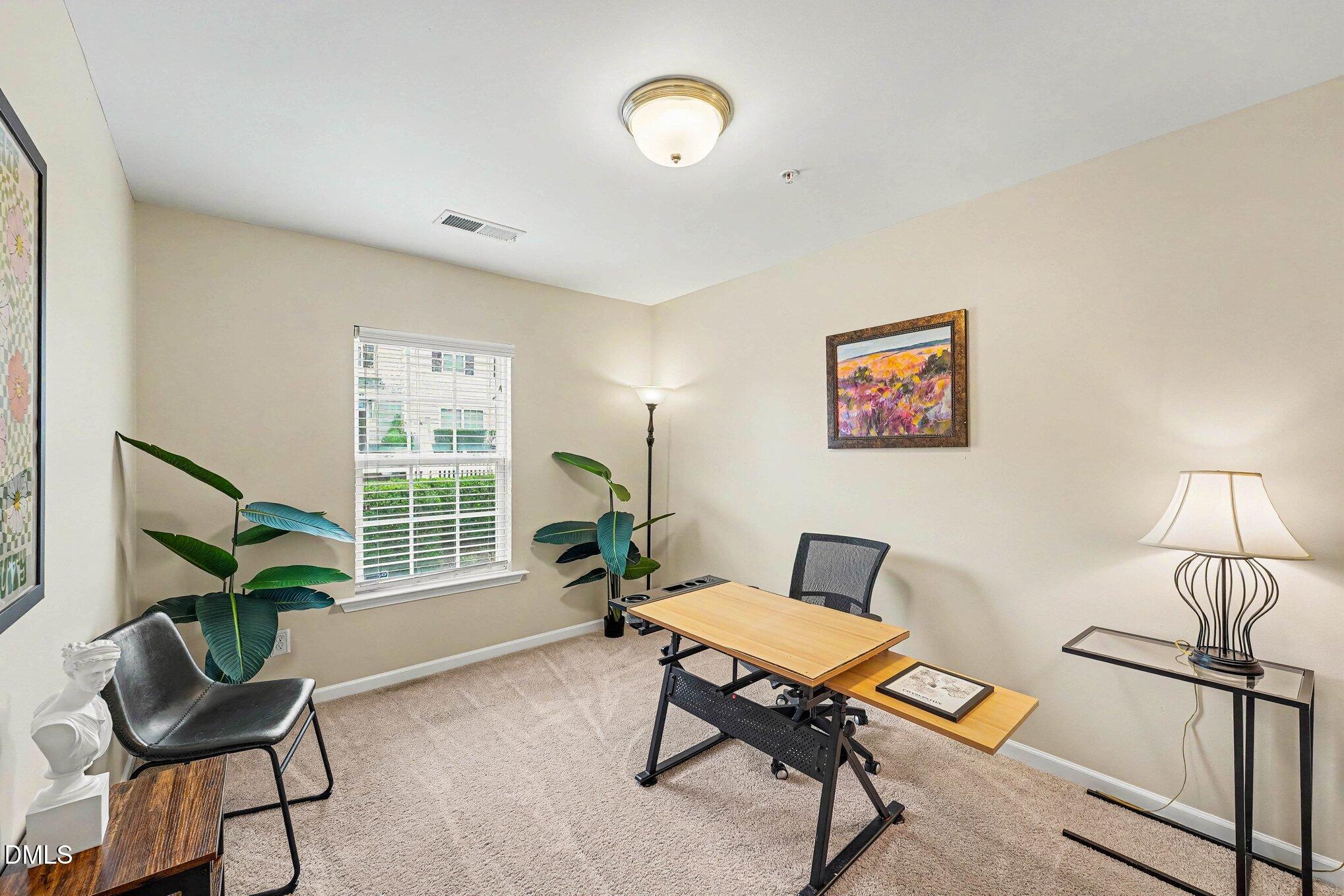 1130 Renewal Place, Unit 106 Raleigh, NC 27603 - Photo 23 of 34 a living room with furniture a window and a potted plant