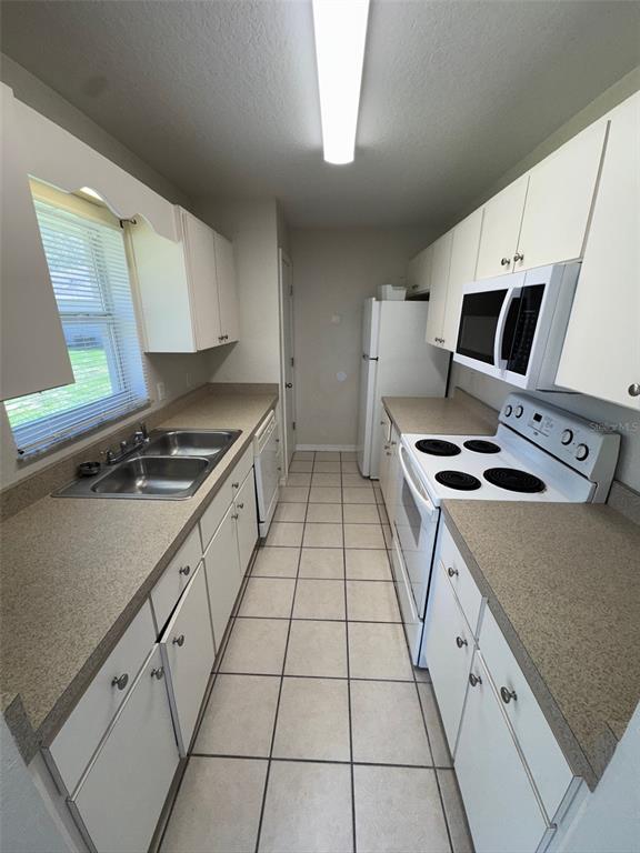 11322 Southeast 55th Avenue Road, Unit 1301 Belleview, FL 34420 - Photo 6 of 20 a kitchen with a sink a stove cabinets and a counter top space