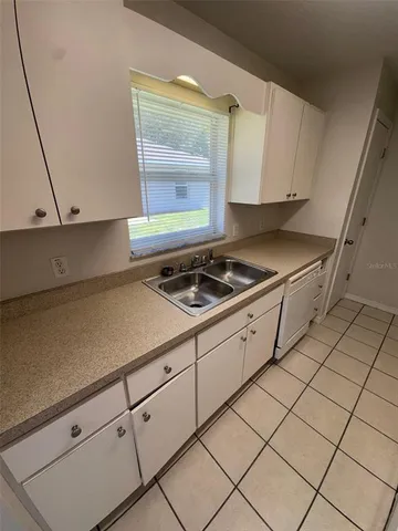 a kitchen with white cabinets and a stove top oven