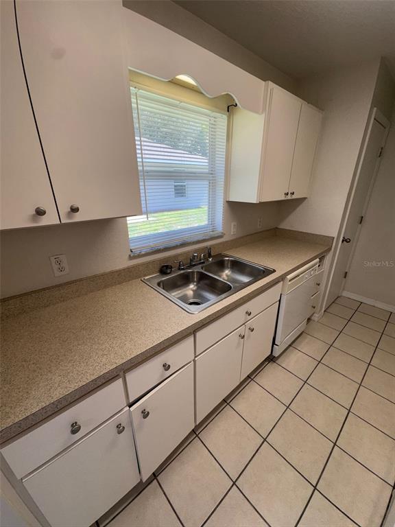11322 Southeast 55th Avenue Road, Unit 1301 Belleview, FL 34420 - Photo 7 of 20 a kitchen with white cabinets and a stove top oven