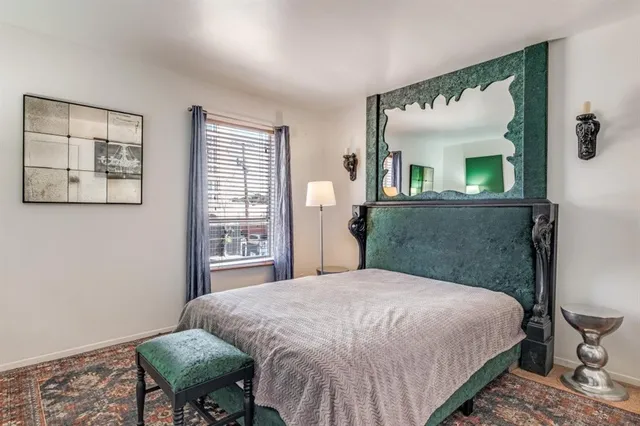 a bedroom with a bed mirror and window