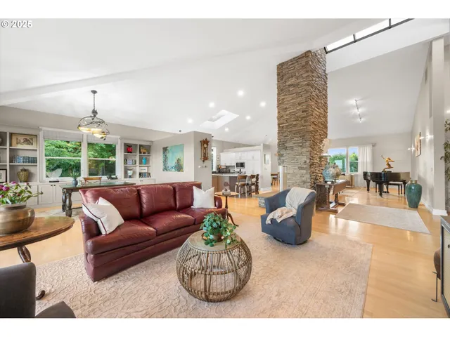 a living room with furniture kitchen view and a large window